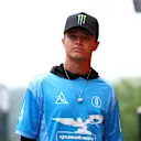 Lando berjalan paddock menjelang 2025 Grand Prix Belgium memakai baju gaya jersi dari kuadran jenamanya sendiri. Leret untuk melihat lebih banyak