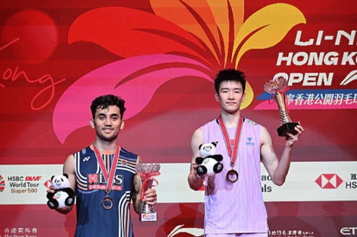 Li Shifeng (R) mengangkat trofi perseorangan lelaki terbuka 2025 Hong Kong selepas kemenangan ke atas Lakshya Sen. (Foto: AFP)